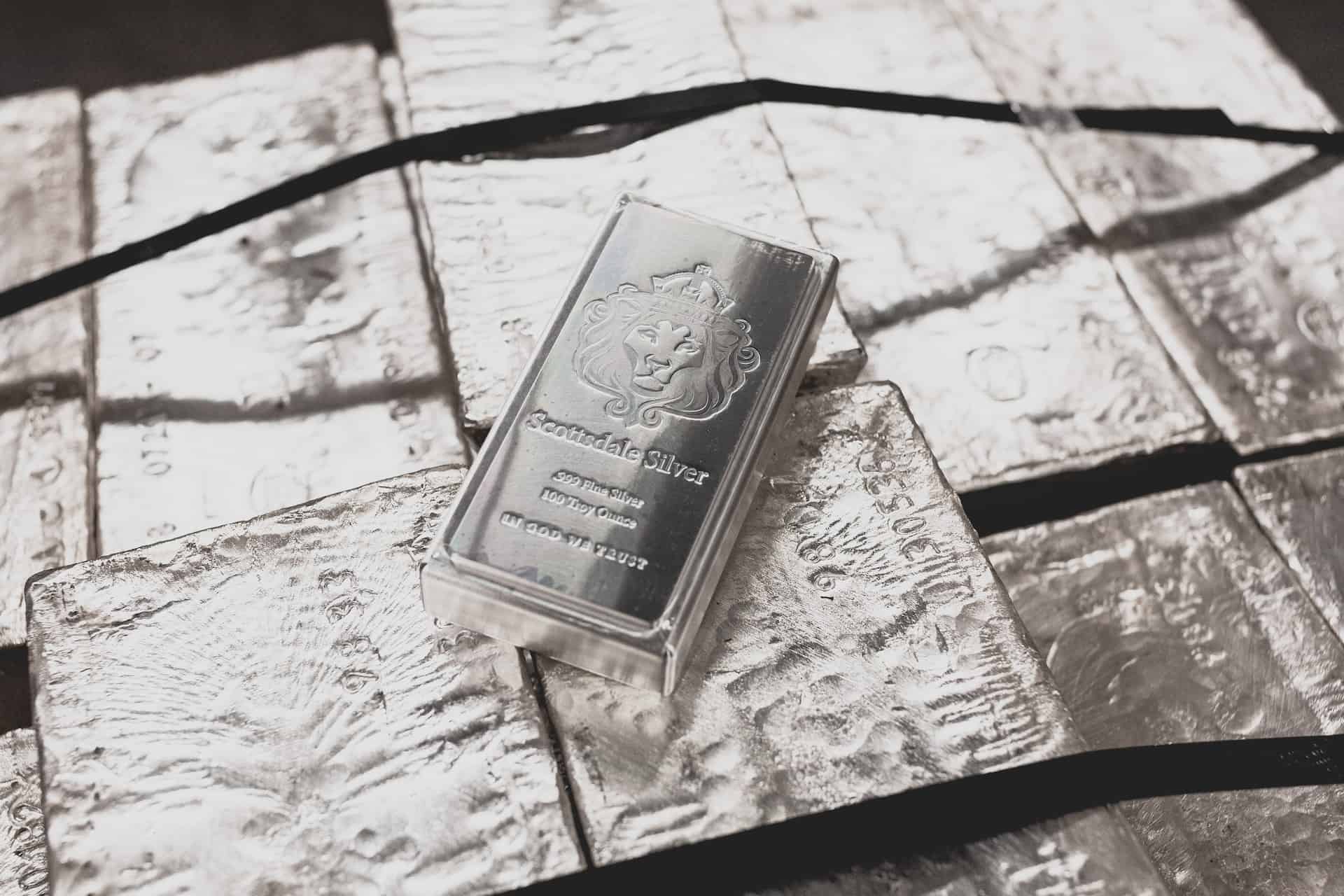 a silver bar laying on top of raw silver