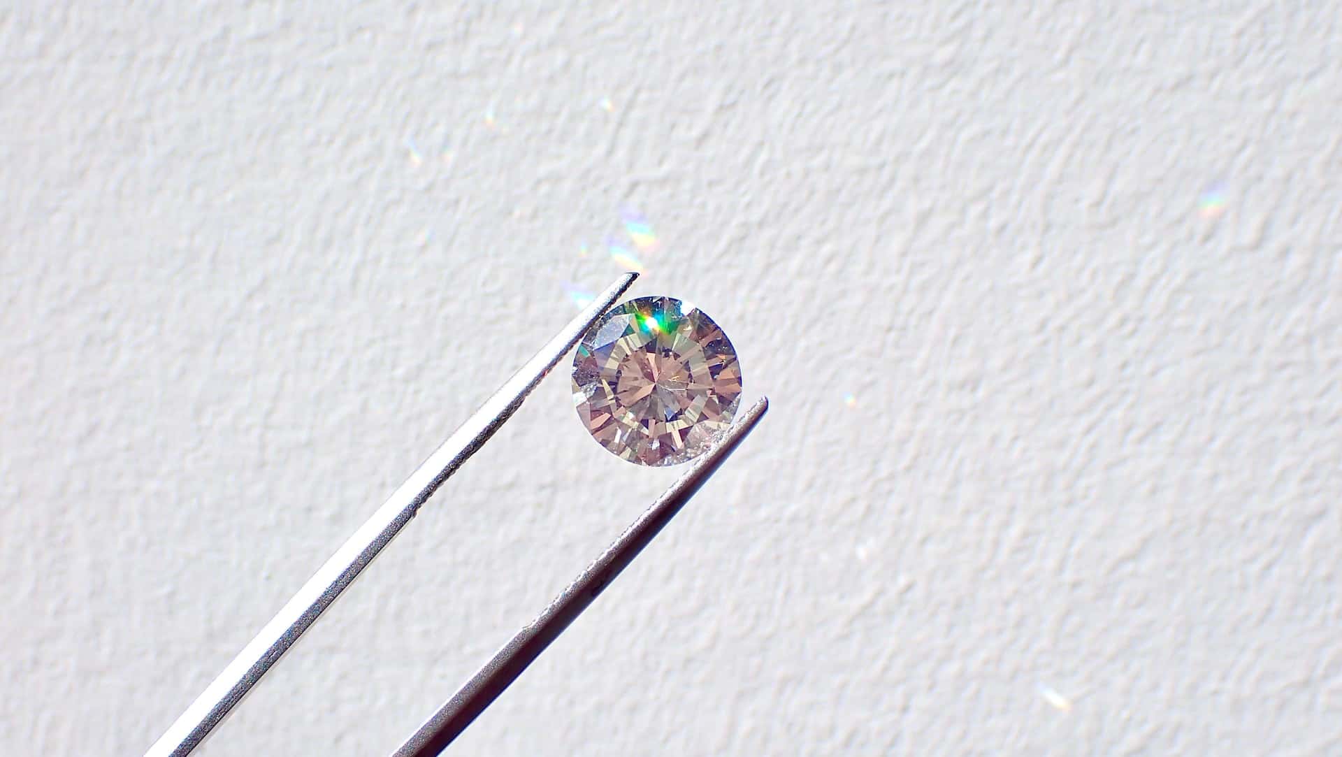 A diamond held up by tweezers