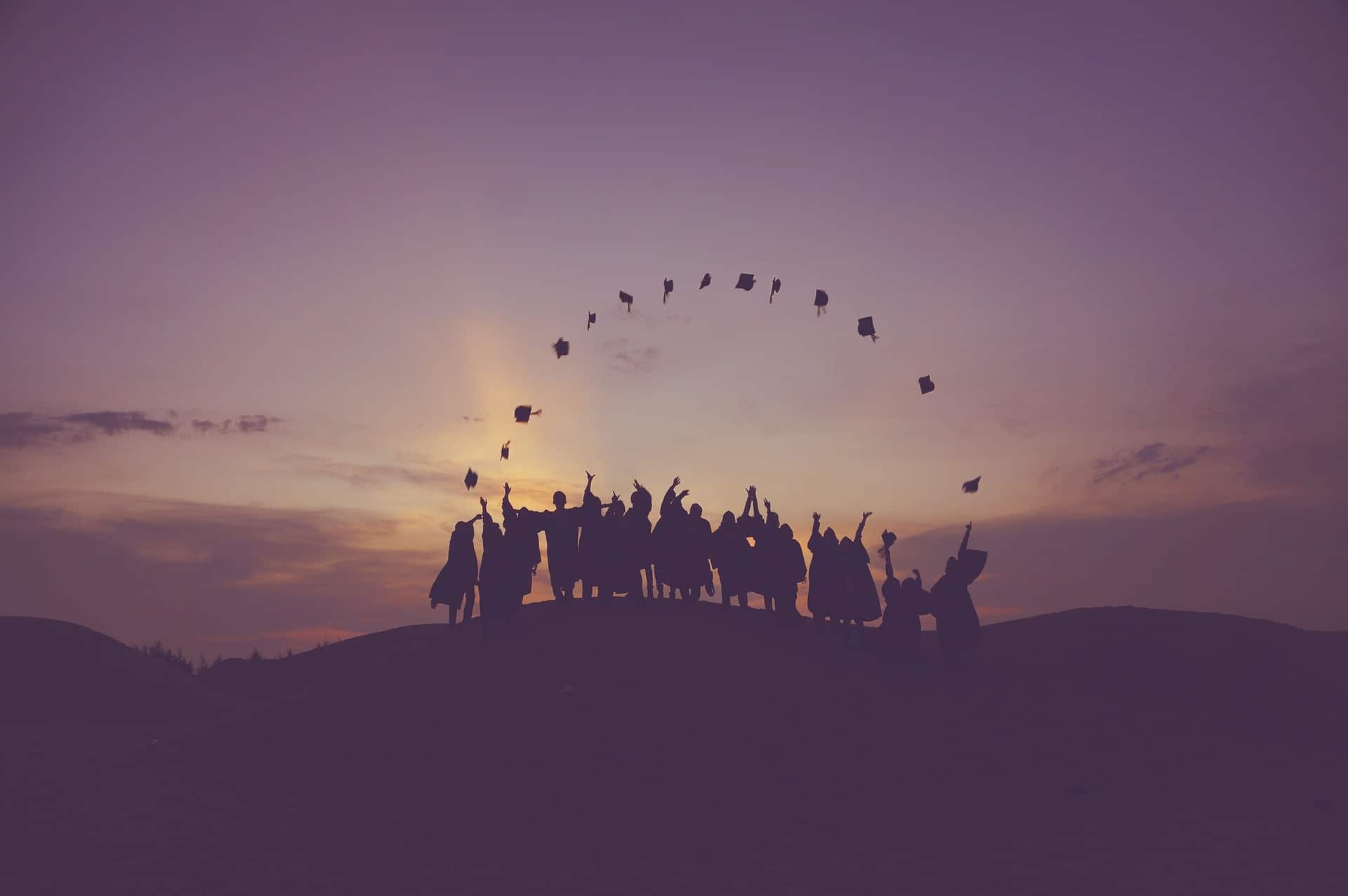 a group of graduates throwing their caps into the air
