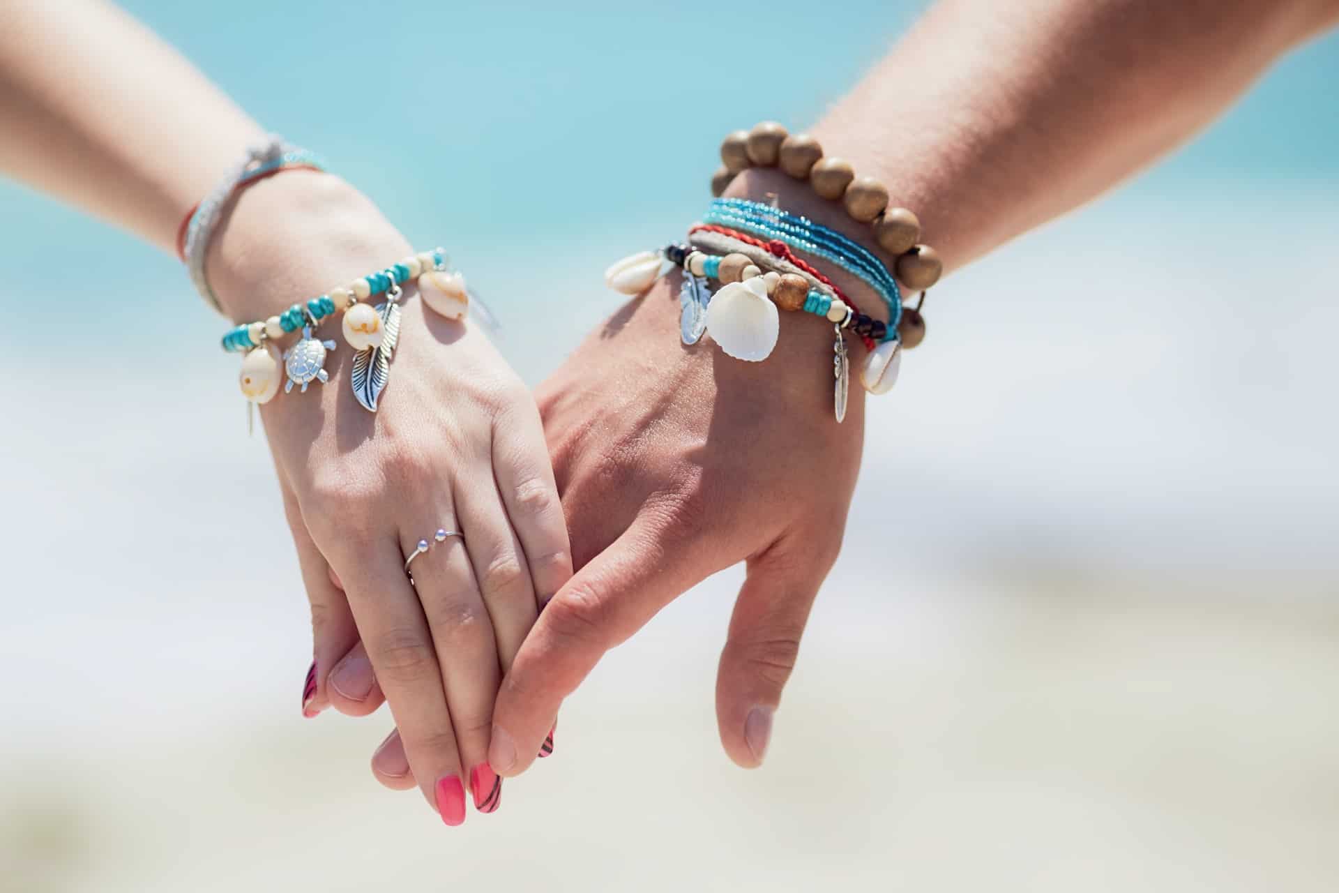 A man and woman wearing jewelry and holding hands
