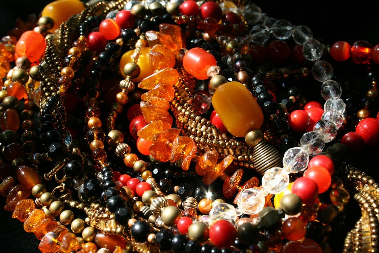 a cluster of black, orange, and yellow beaded jewelry in a pile
