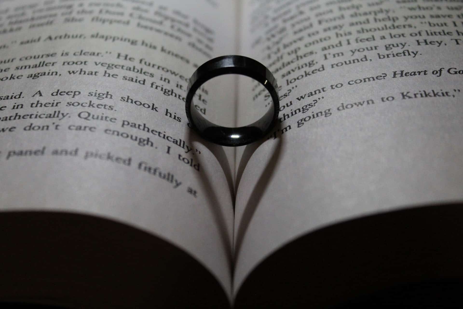 A ring in the fold of a book causing a heart-shaped shadow.