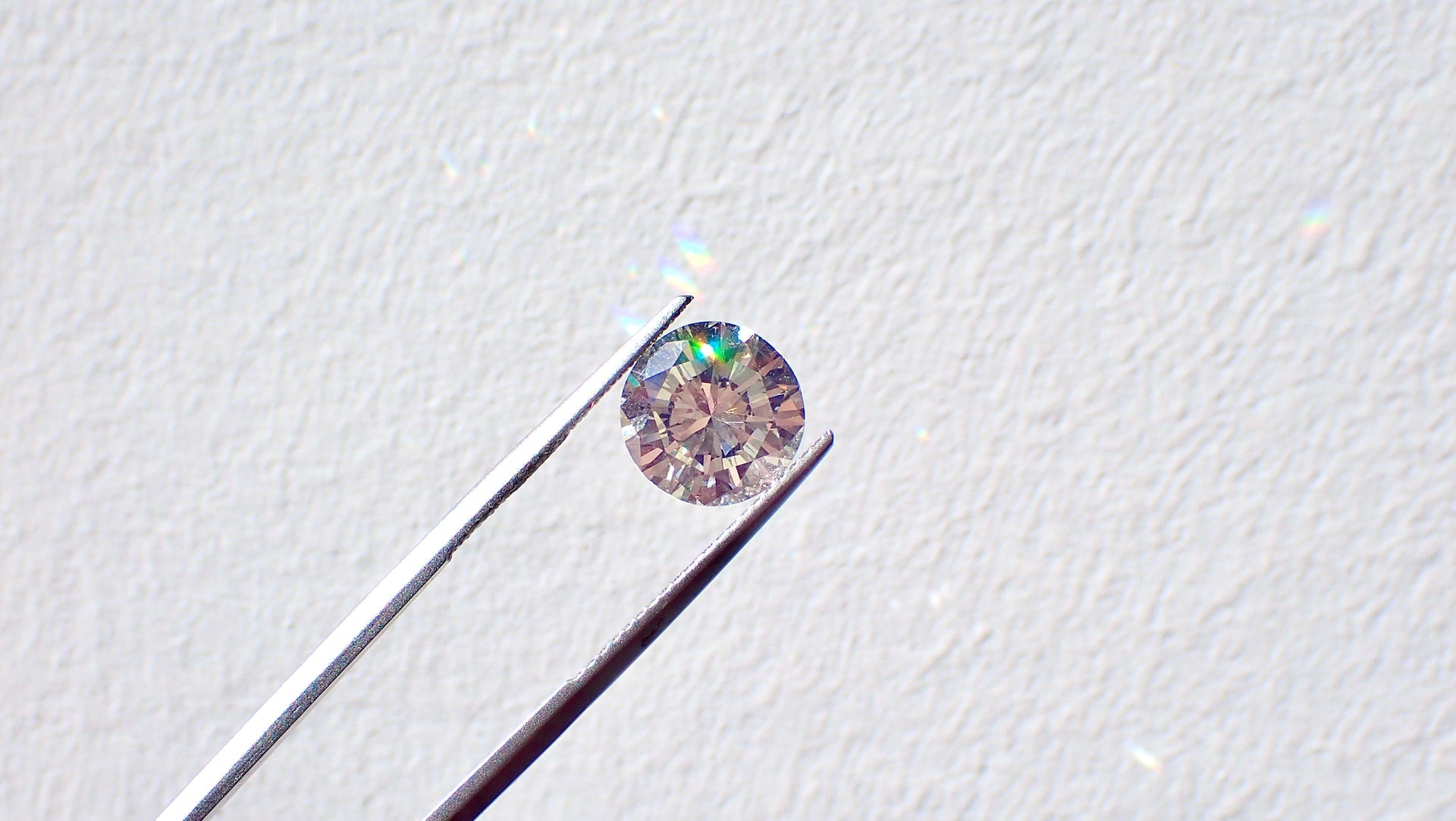 Round diamond between tweezers