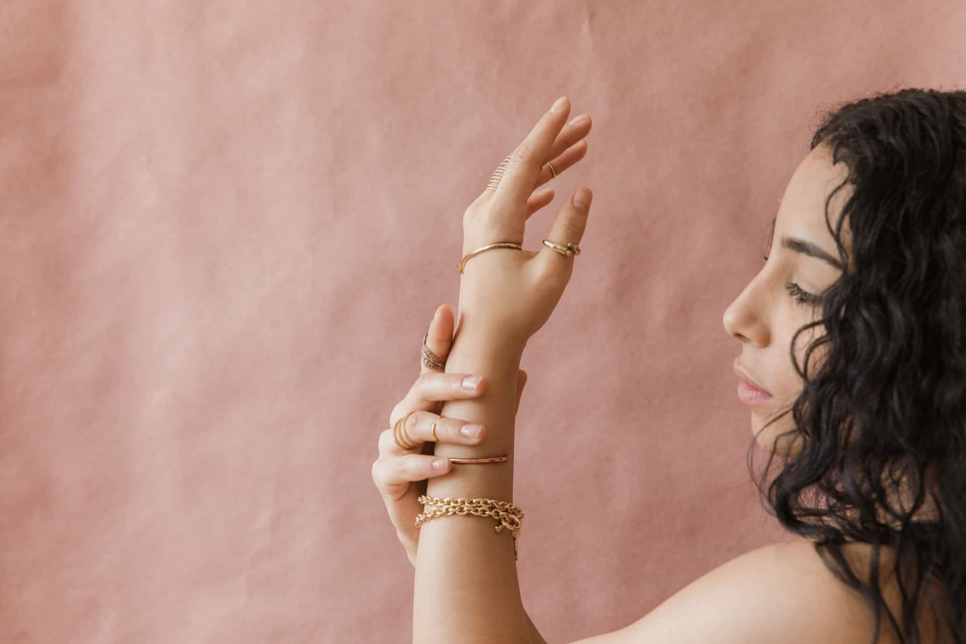 woman looking at bracelets on her arm