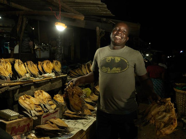 Mr Moyo using a solar light the fish market