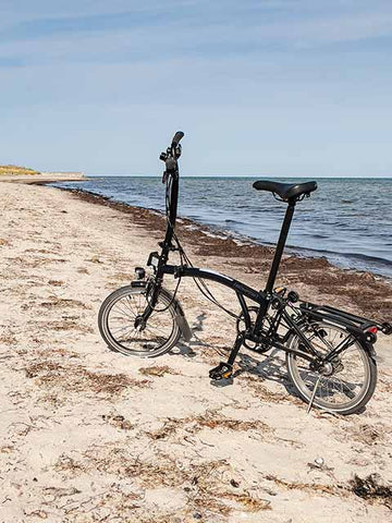 Brompton mit Fahrradständer am Strand