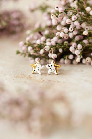 A pair of earrings in a gold lustre star design for Christmas