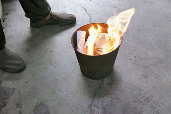 Raku fired ceramic pottery being placed in reduction chamber