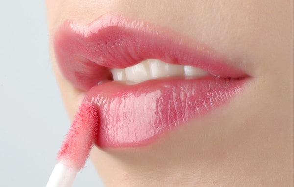 Lady putting a pink lipstick