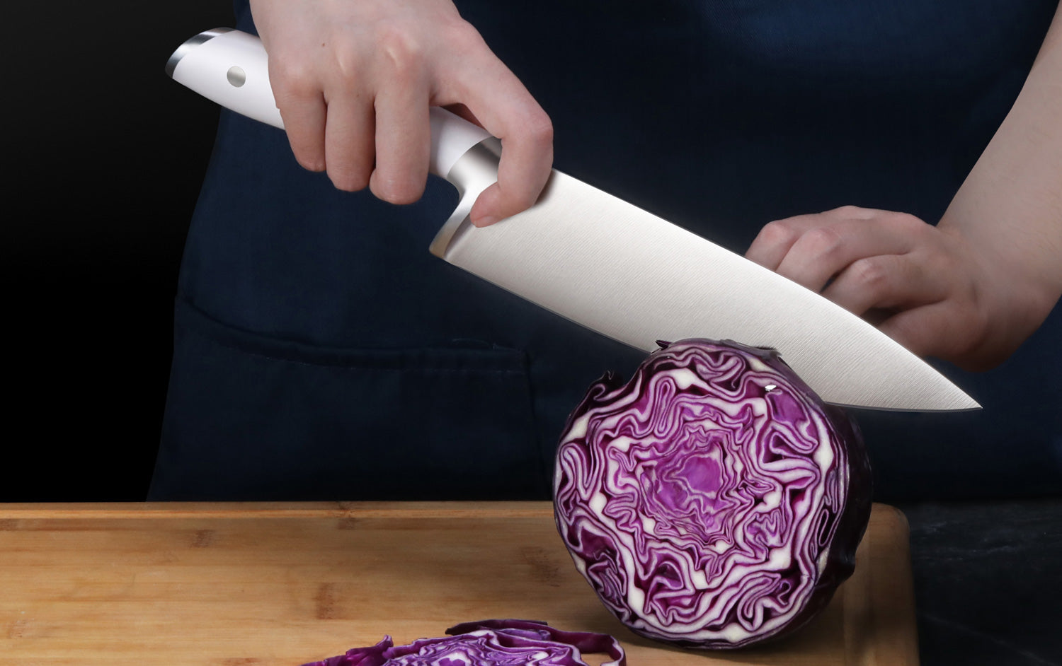 Lifestyle shot of an ALPS Series chef's knife cutting through red cabbage.