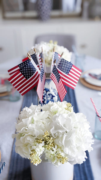 4th of July Party Decorations: table centerpieces including two vases with hydrangeas and a chinoirsie vase with American flags.