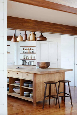 Natural wood kitchen island with wooden bowl accents and wooden beams showcasing how to incorporate natural design elements into your home