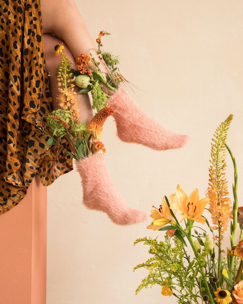 Twee voeten met bloemen in roze sokken
