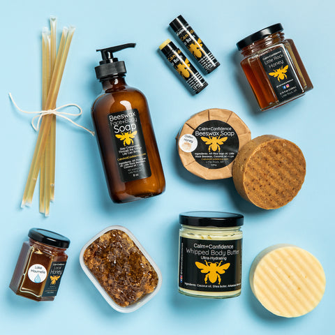 Variety of honey and beeswax products with dark labels and bright background