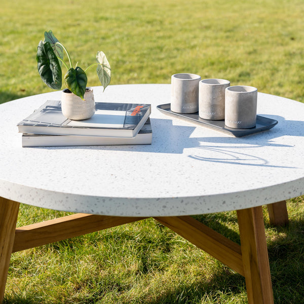 Terrazzo table with candles, coffee table books and a plant