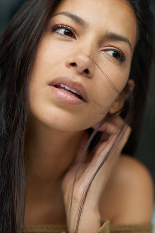 Model posing with clear, glowy, hydrated skin