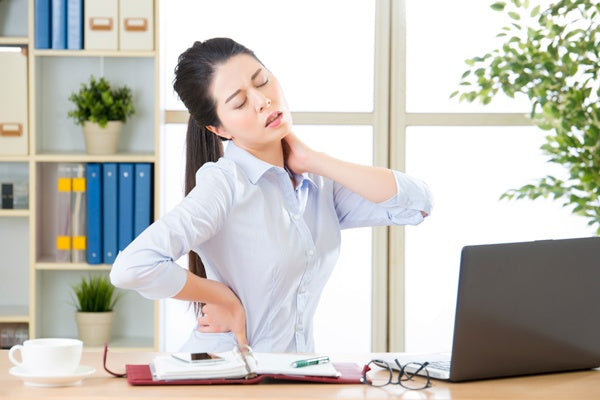 girl with back pain and neck pain sitting in her office desk
