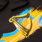 Detail of the Guinness Storehouse Exclusive black hoodie with the iconic Guinness harp on orange and blue texture.
