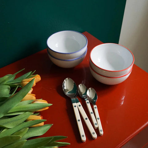 Sabre Bistrot cutlery in Ivory on red tabletop with bowls and flowers