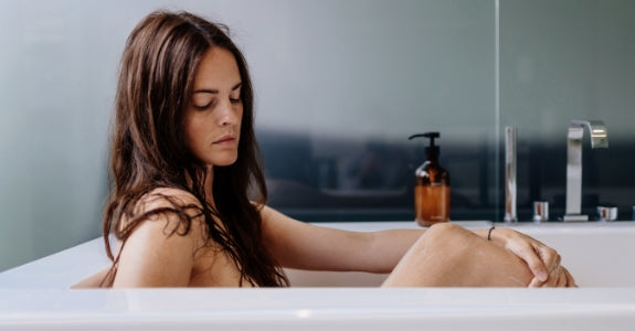 EQUA CARE Our story and mission - lady sitting in a tub and washing herself with EQUA CARE body shower gel