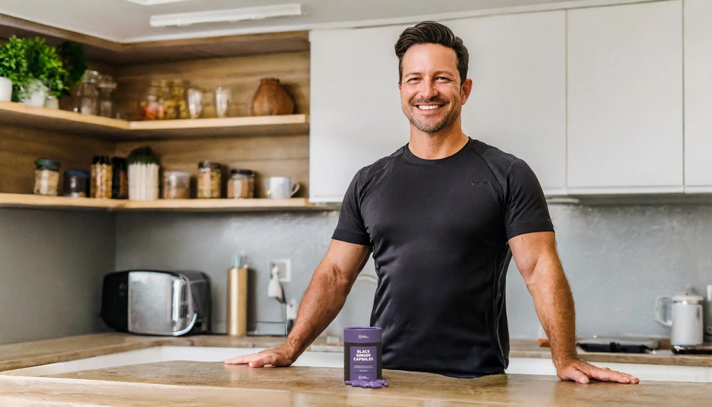 Man in kitchen with Black Ginger Capsules from Nood Nutrition