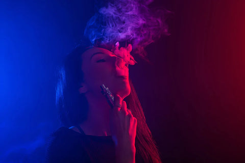 Lady vaping against dark coloured background