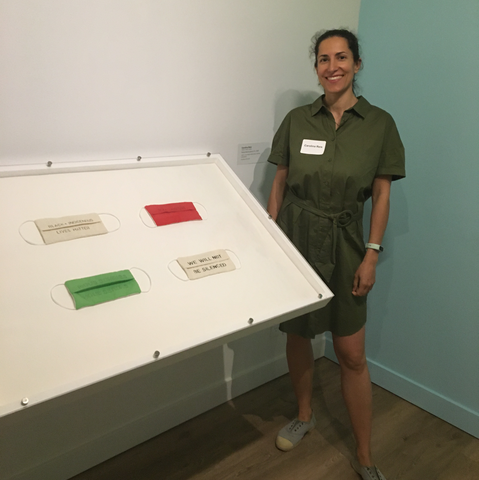 carolina reis standing next to her work exhibited at the Textile Museum of Canada