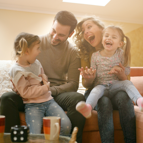 Familia con dos niñas pequeñas jugando felices