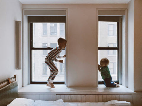 Niños jugando ventana seguridad en casa