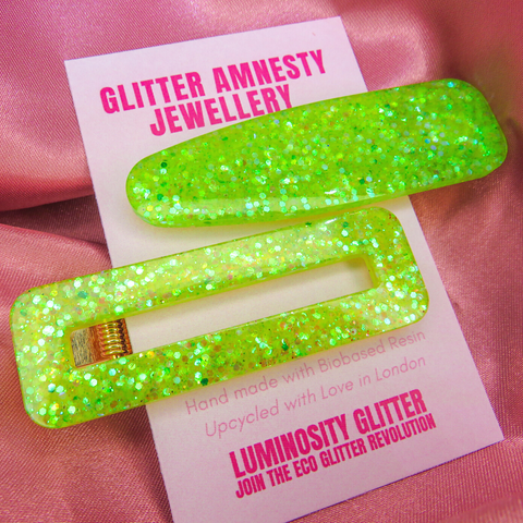 Neon green and yellow glitter hair clips by Luminosity Glitter on a pink backing card