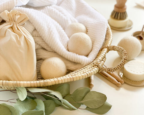 Dryer balls in a basked with laundry and leaves. 