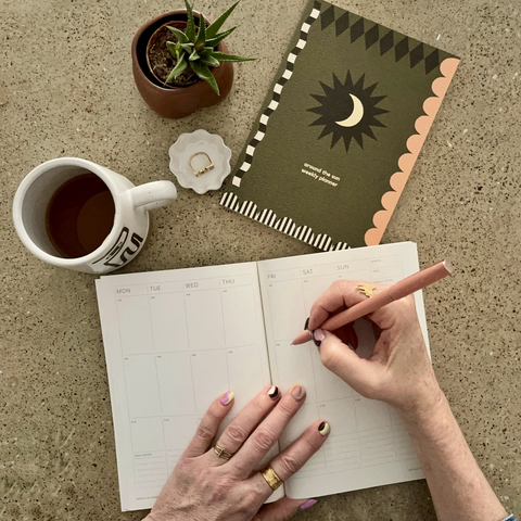 lady sat writing in a journal from a birds eye view