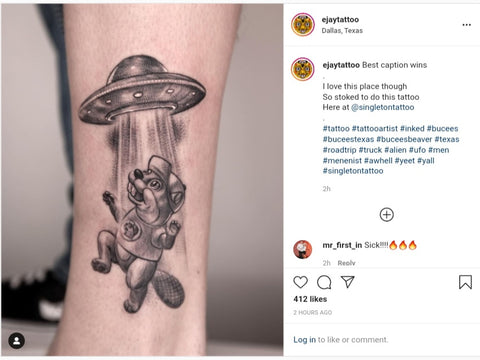 Instagram post from @ejaytattoo of arm tattoo of Buc-ee being abducted by aliens in a UFO