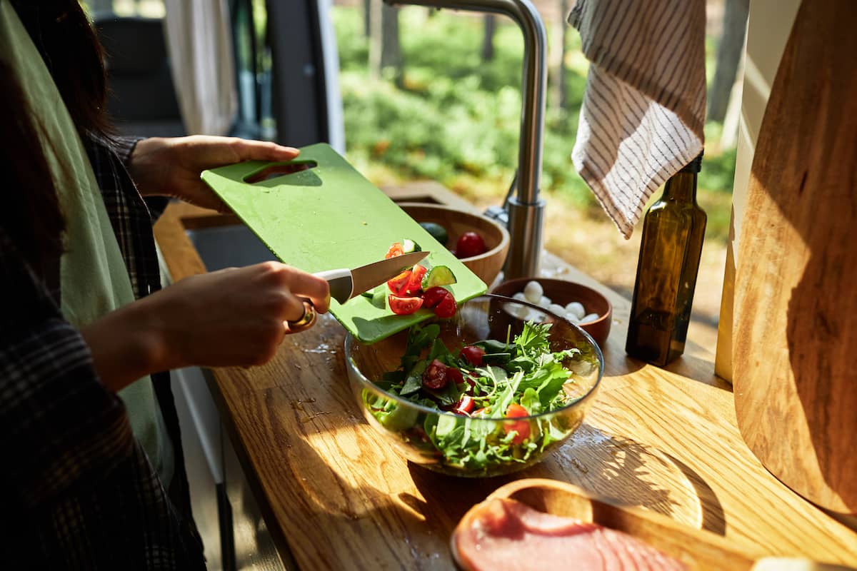 Girl preparing a salad in a van