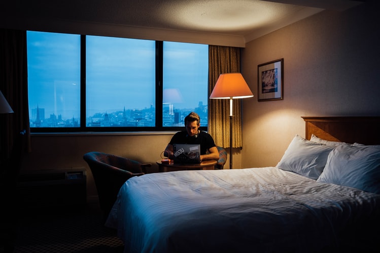 quelqu'un regardant son ordinateur dans sa chambre