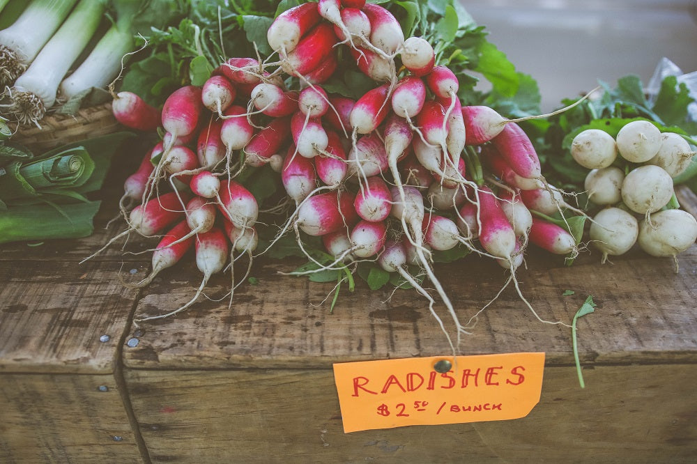 bunches of radishes on a market stall
