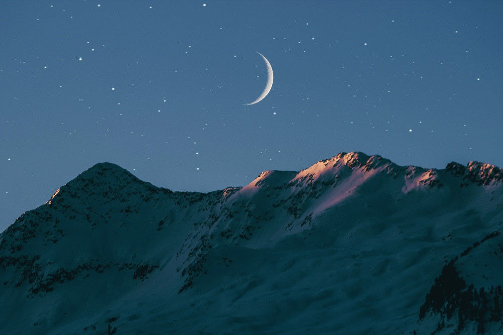 crescent moon above the mountains