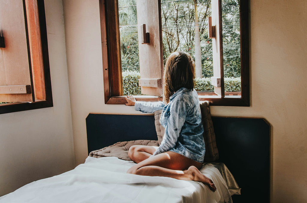 femme assise sur son lit en pyjama