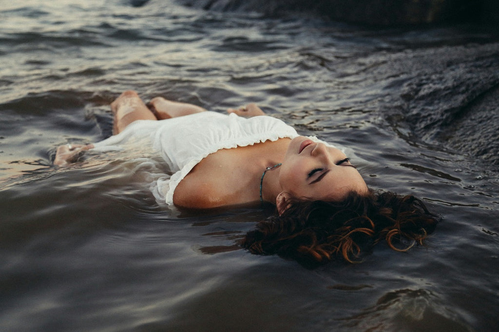 femme dans l'eau allongée sur le dos