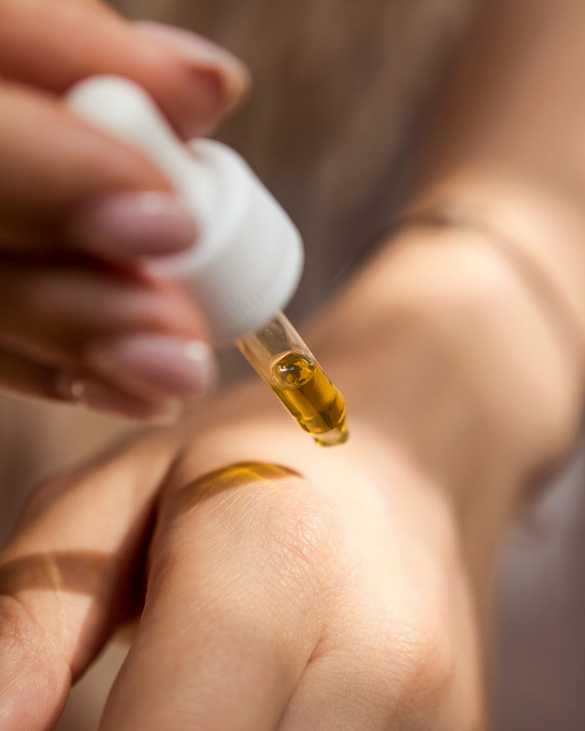 woman putting CBD drops on her hand