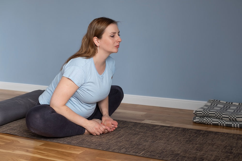 femme enceinte dans la posture de yoga du papillon