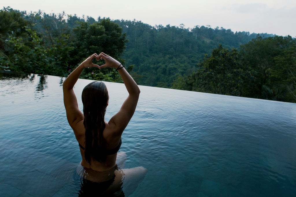 naked woman in a swimming pool with sea view