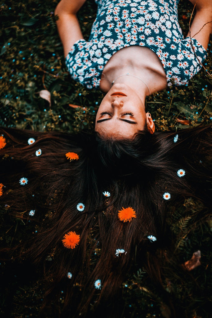 jeune femme allongée avec des fleurs dans les cheveux