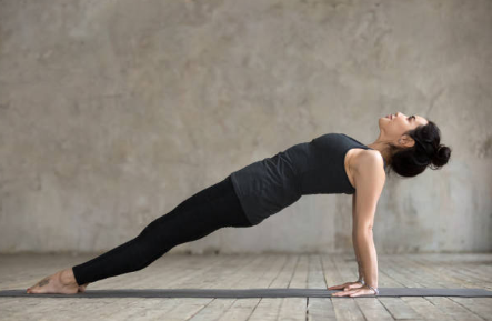jeune femme dans la posture de yoga de la planche inversée