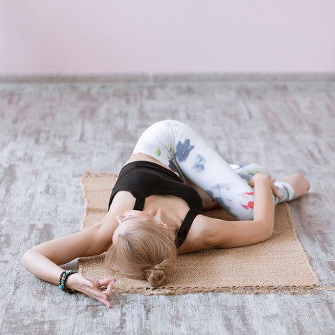jeune femme dans la posture de yoga torsion au sol