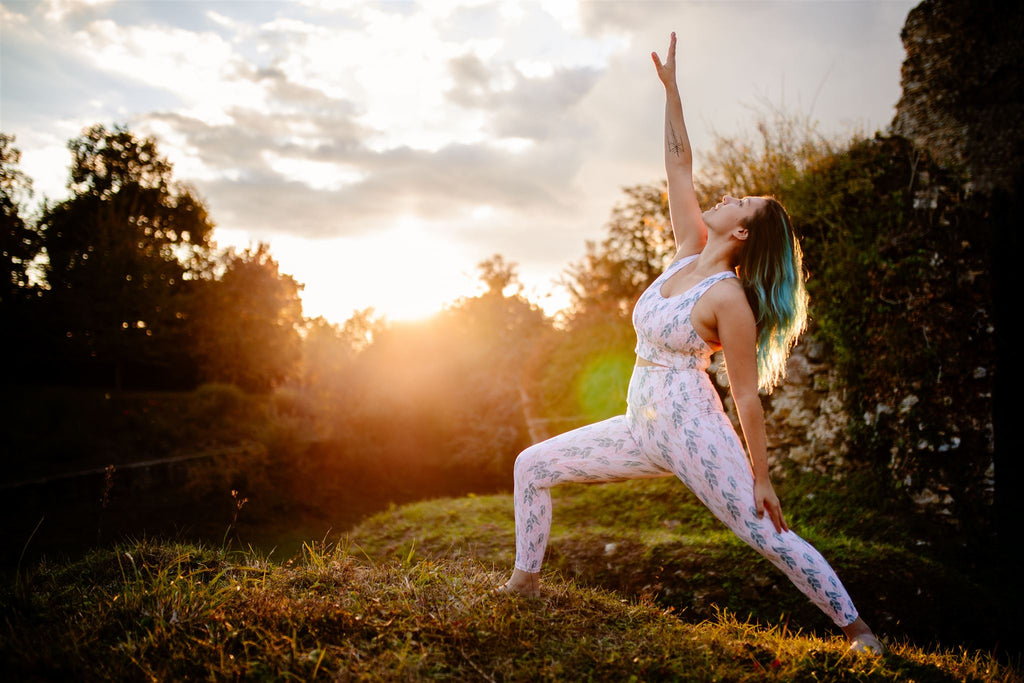 young woman in warrior pose at sunset