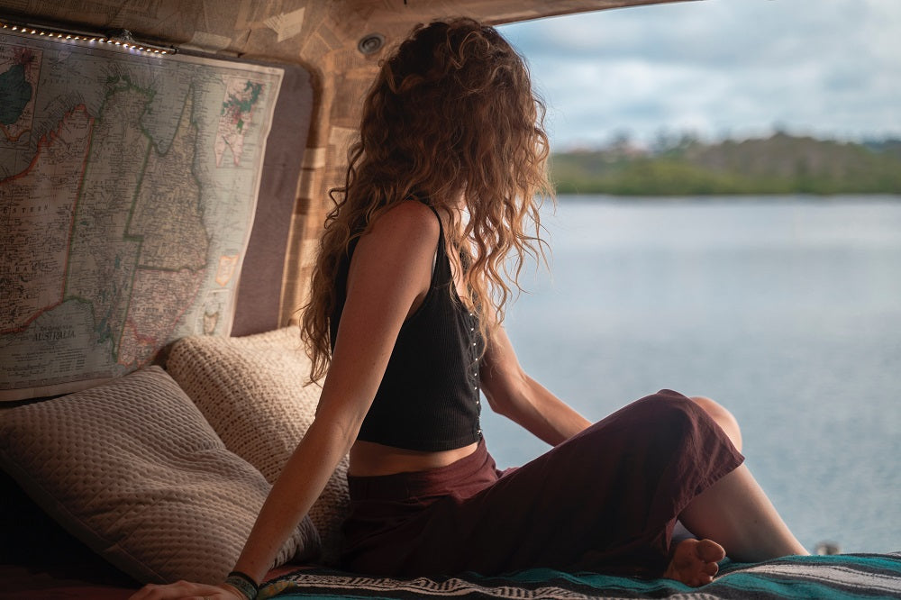 jeune femme de dos regardant la mer par la fenêtre