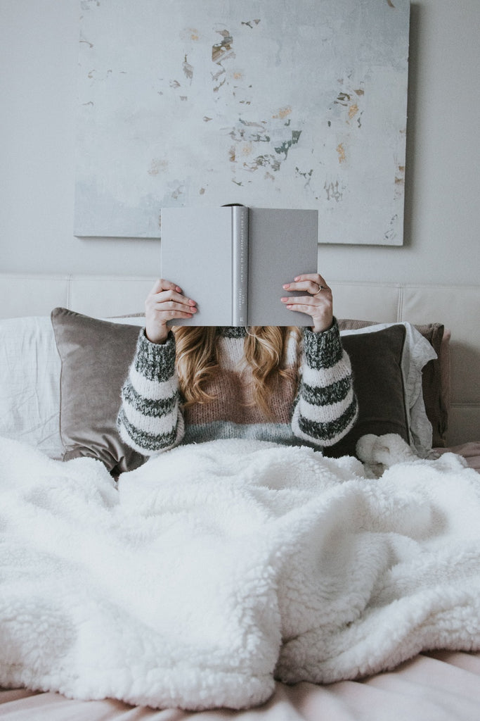 jeune femme lisant dans son lit