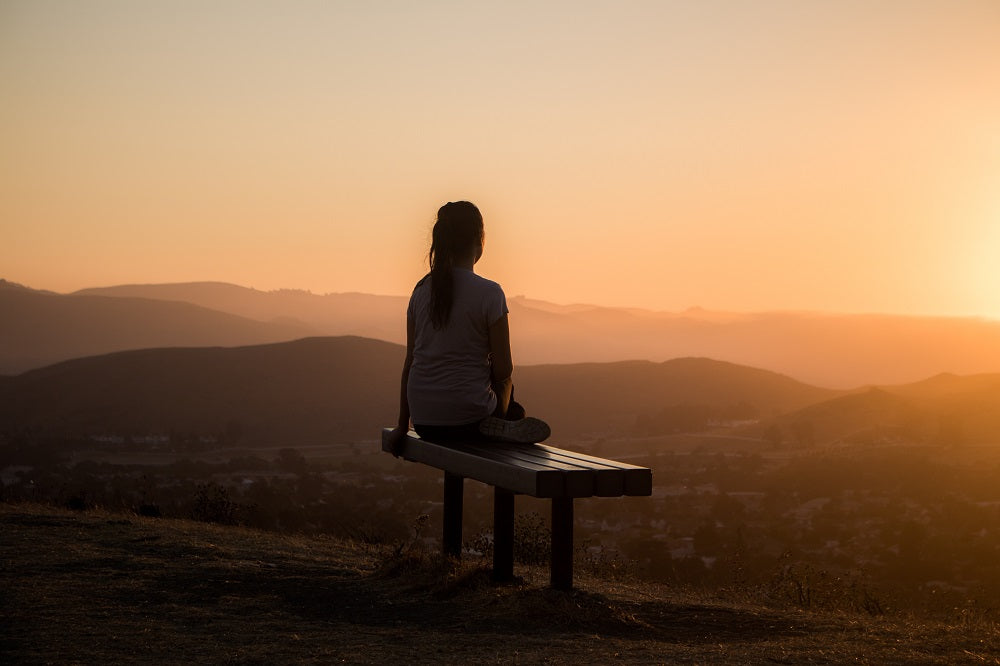 young woman meditating at dusk