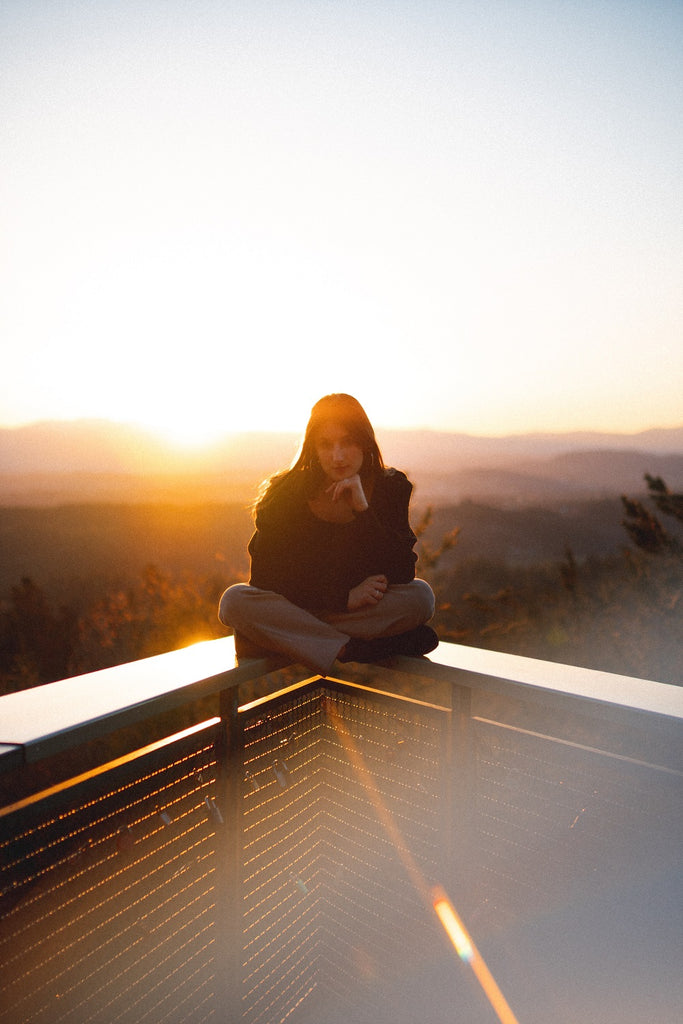 jeune femme méditant dans le soleil couchant